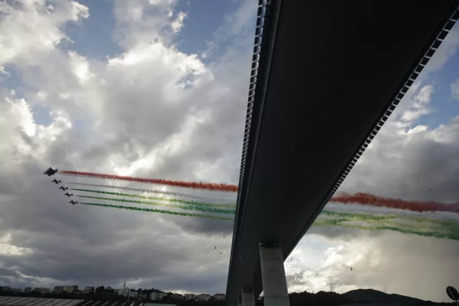 Italian Air Force aerobatic jet fly over the new San Giorgio Bridge (Luca Bruno/AP)
