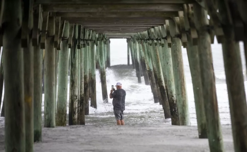 A person stands under the pier in Garden City, South Carolina (Jason Lee/AP)