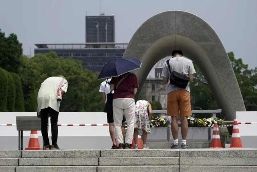 People pay respect in front of the cenotaph for the atomic bombing victims in Hiroshima (Eugene Hoshiko/AP)