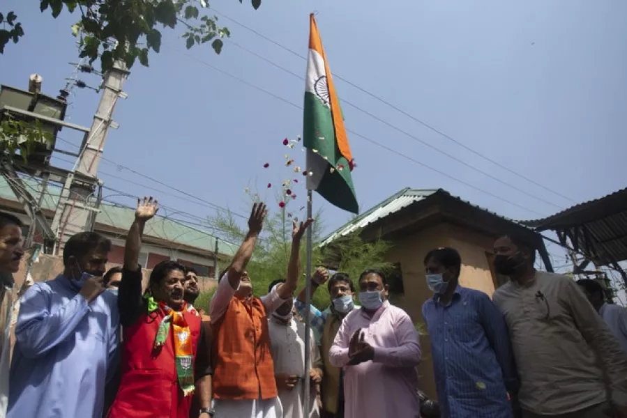 Kashmiri activists of India’s ruling Bharatiya Janata Party (BJP) raise slogans after hoisting the national flag as they mark the first anniversary of India’s decision to revoke the disputed region’s semi-autonomy, in Srinagar, Indian controlled Kashmir (Mukhtar Khan/AP)