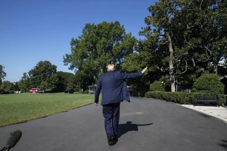 President Donald Trump waves as he departs after speaking with reporters while walking to Marine One on the South Lawn of the White House (Alex Brandon/AP)