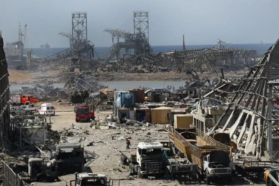 Rescue workers and security officers work at the site of the explosion (Hussein Malla/AP)