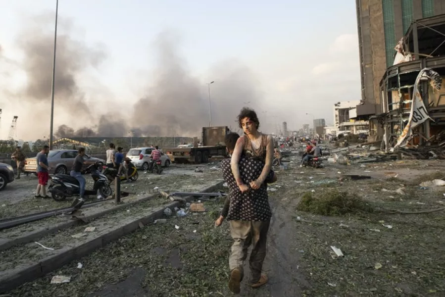A wounded woman is carried away from the site on Tuesday (Hassan Ammar/AP)