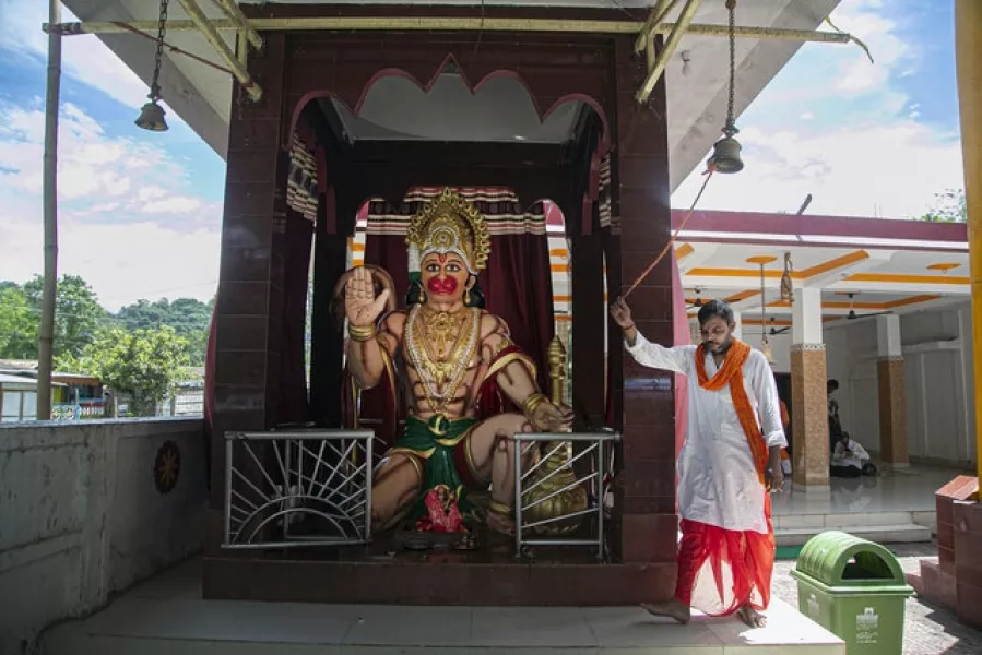 A Hindu priest rings a temple bell as devotees perform special prayers (AP)