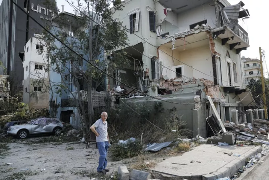 A Lebanese man stands next to his damaged house in Beirut (Hussein Malla/AP)