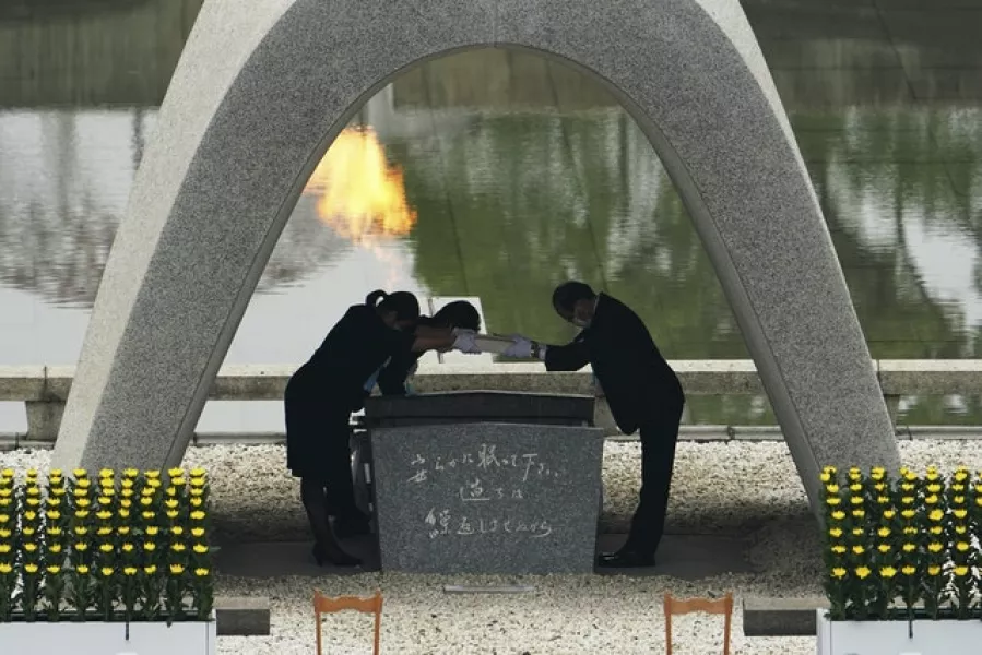 Kazumi Matsui, right, mayor of Hiroshima, and the family of the deceased bow before they place the victims list of the Atomic Bomb at Hiroshima Memorial Cenotaph during the ceremony (AP Photo/Eugene Hoshiko)