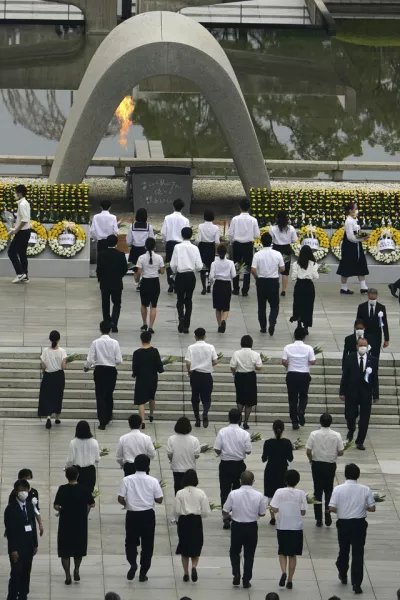 The families of the deceased offered flowers to Hiroshima Memorial Cenotaph (AP Photo/Eugene Hoshiko)