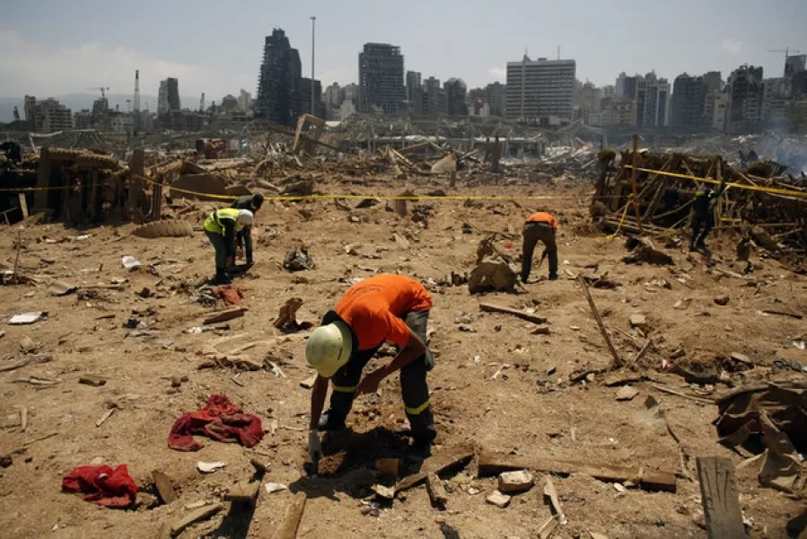 Volunteers conduct research on the site of the blast (Thibault Camus/AP)