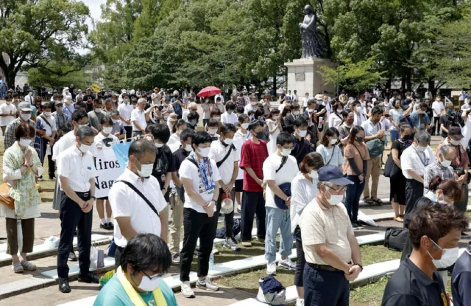 People offer silent prayer for the victims the bombing (Takuto Kaneko/Kyodo News/AP)