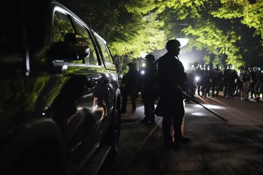 Police walk through the Laurelhurst neighbourhood (AP/Nathan Howard)