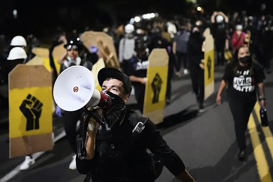 A protester leads a crowd of demonstrators toward the Multnomah County Sheriff’s Office (AP/Nathan Howard)