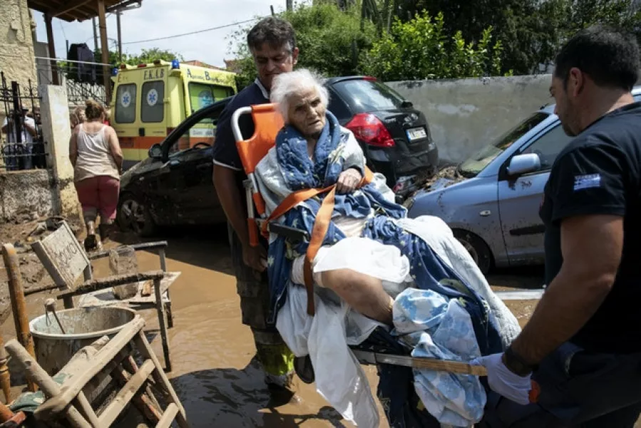 A woman is evacuated from her home by paramedics (AP/Yorgos Karahalis)