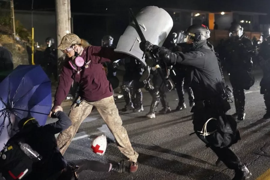 A Portland police officer shoves a protester (AP)