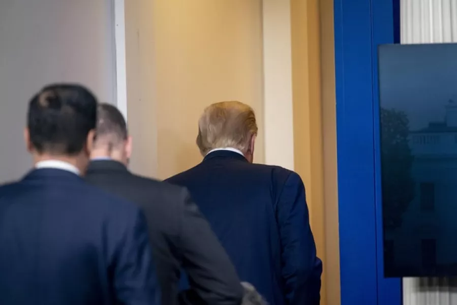 President Donald Trump leaves the James Brady Press Briefing Room with a member of the secret service (Andrew Harnik/AP)