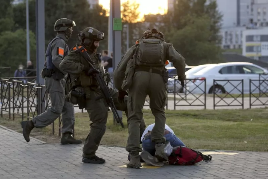 Police kick a demonstrator on the ground (AP)