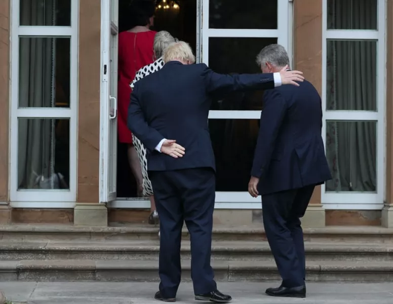 Boris Johnson gestures for Brandon Lewis to enter the door ahead of him at Hillsborough Castle (Brian Lawless/PA)