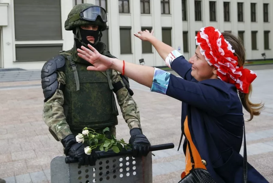 A woman embraces a soldier guarding the Belarusian Government building (Sergei Grits/AP)