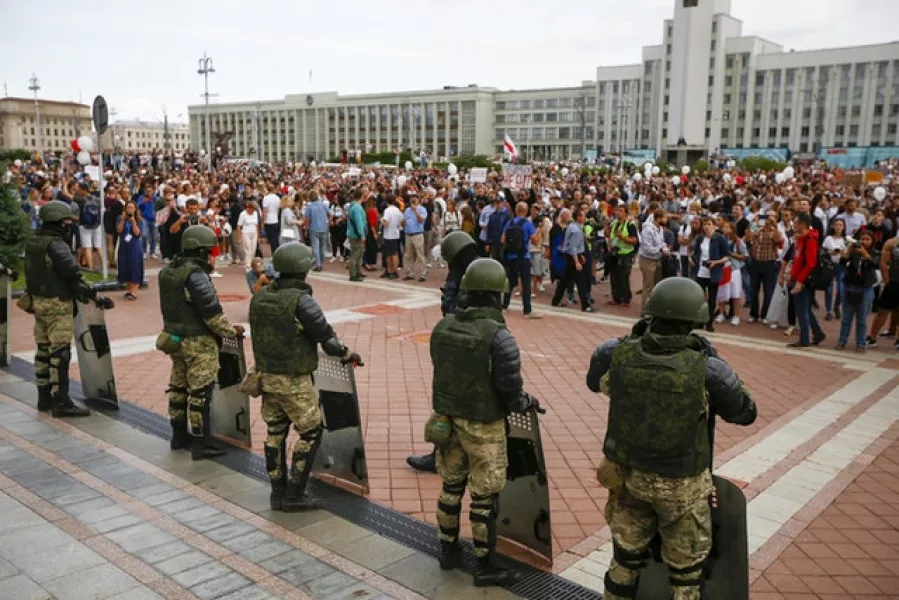 People gather in front of soldiers guarding the Belarusian Government building in Minsk (Sergei Grits/AP)