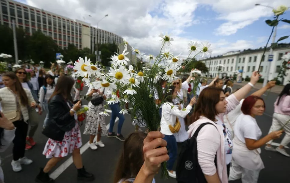Belarusian women carry flowers on a rally in solidarity with protesters injured in the latest rallies against the results of the country’s presidential election (Sergei Grits/AP)