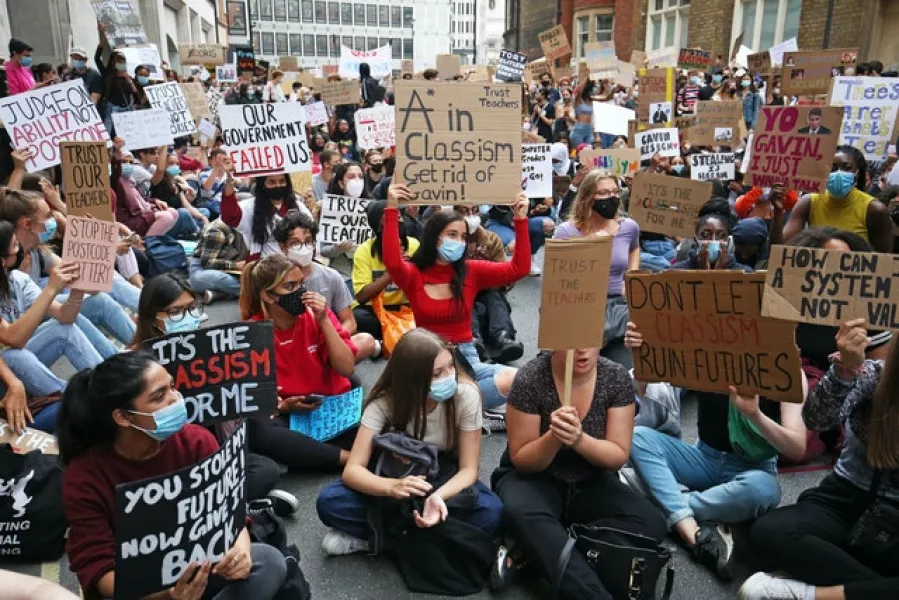 People take part in a protest outside the Department for Education in London in response to the downgrading of A-level results (Jonathan Brady/PA)