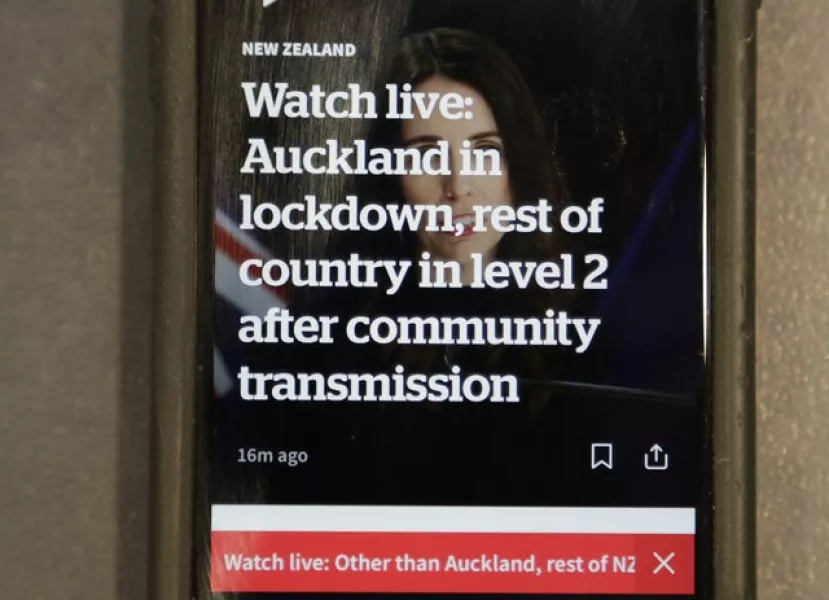 A news alert is displayed on a mobile phone in New Zealand last week (Mark Baker/AP)