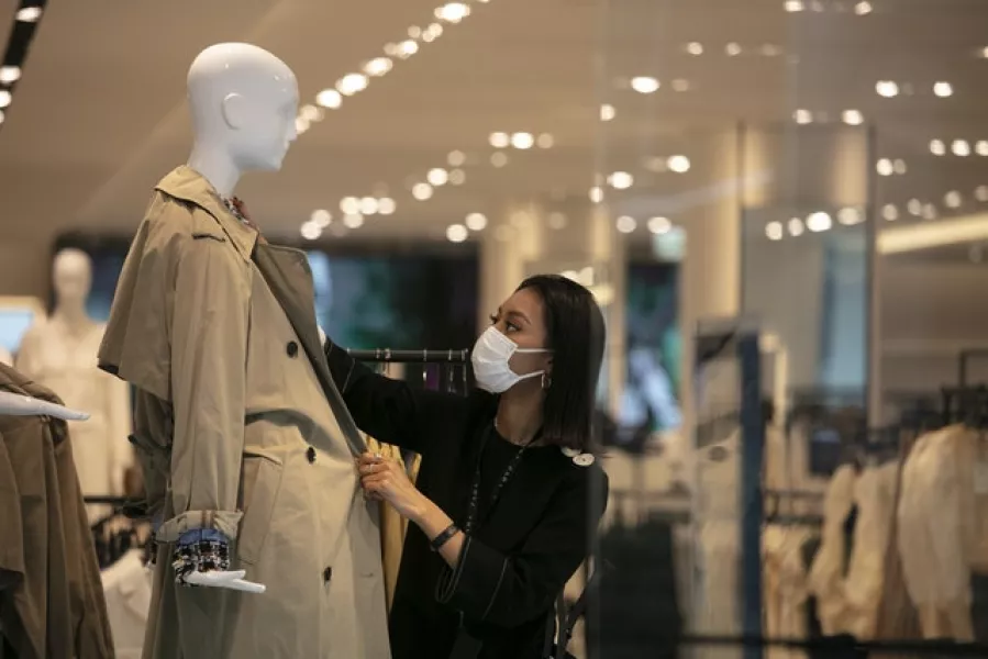 A department store employee dresses a mannequin in Tokyo. Japan is hoping the major factors of its economy, including retail sales, soon begin to recover from the coronavirus pandemic (Jae C. Hong/AP)