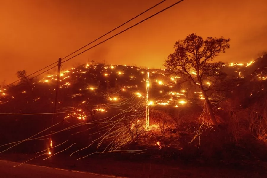 Seen in a long exposure photograph, embers burn along a hillside in Napa County (Noah Berger/AP)