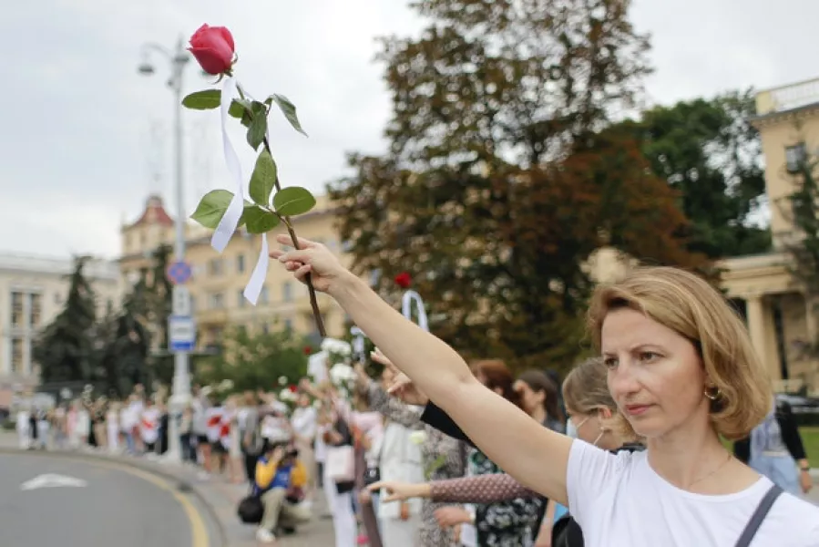 Opposition supporters hold flowers during a protest in Victory Square in Minsk, Belarus (Sergei Grits/AP)
