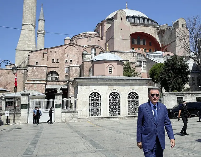 Turkey’s President Recep Tayyip Erdogan arrives to speak to supporters and the media after Friday prayers in Hagia Sophia, in the background, in Istanbul (AP)