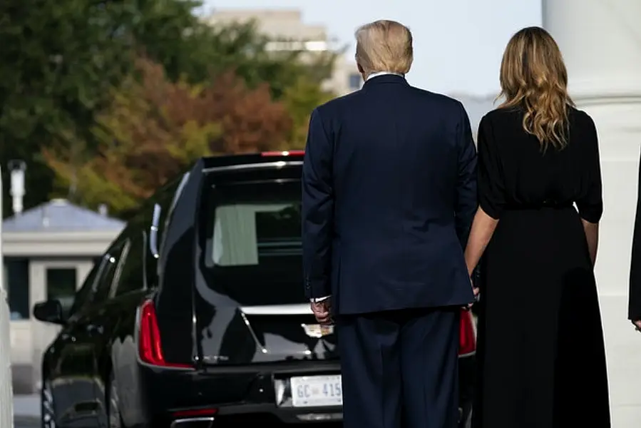 President Donald Trump and first lady Melania Trump watch as the coffin of Robert Trump leaves the White House (Evan Vucci/AP)