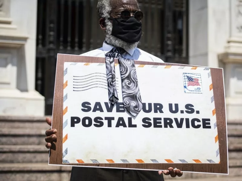 A Postal Workers Union representative at a protest against the service’s budget cuts in Los Angeles this week (Sarah Reingewirtz/The Orange County Register/AP)