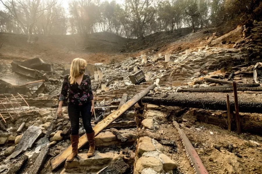 A woman examines the remains of a home in Vacaville, California (Noah Berger/AP)