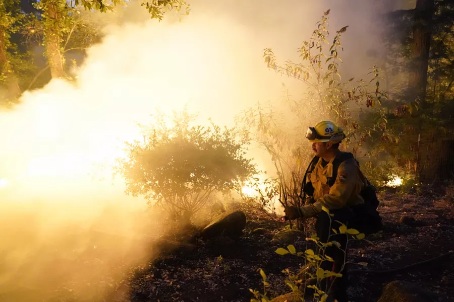 A firefighter monitors a controlled burn in Boulder Creek (Marcio Jose Sanchez/AP/PA)