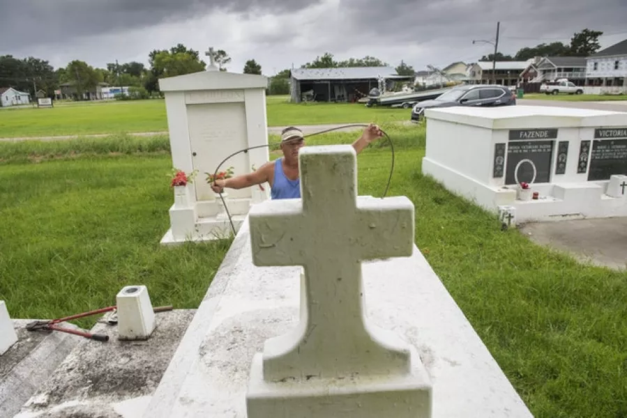 Steel cable and metal anchors are used to tie down tombs in a small cemetery in Louisiana (Chris Granger/The Times-Picayune/The New Orleans Advocate via AP)