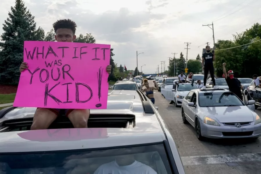 A protester sits on a car in the city of Kenosha (Morry Gash/AP)