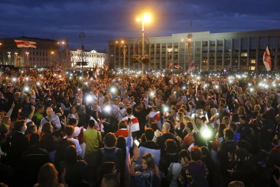 Opposition supporters light their phones as they gather at Independence Square in Minsk (Sergei Grits/AP)
