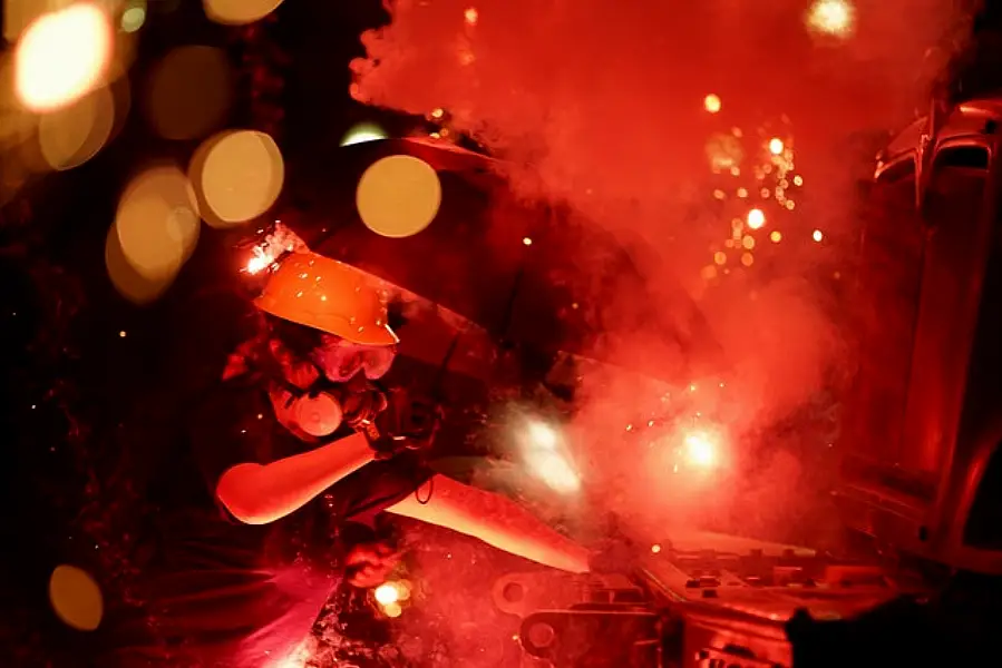 An explosive device detonates as a protester pushes back on an armoured vehicle (AP)