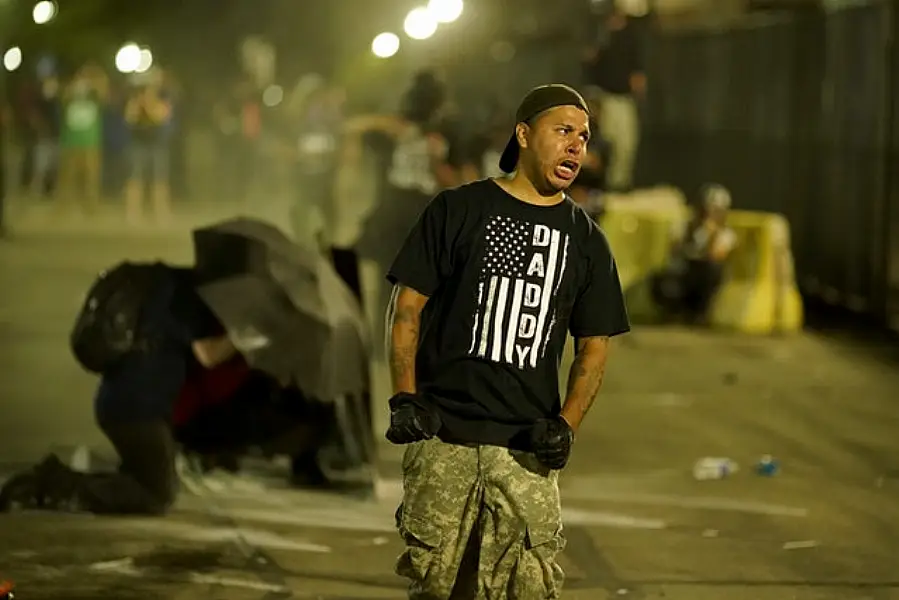 A protester shouts at police in riot gear during fresh protests in Kenosha (AP)