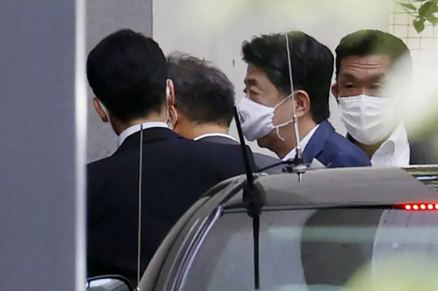 Japanese prime minister Shinzo Abe, centre right, arrives at Keio University Hospital in Tokyo (AP)