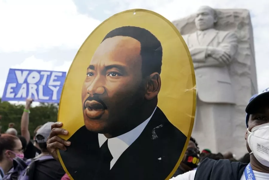 A man holds a photo of Martin Luther King, Jr (Carolyn Kaster/AP)