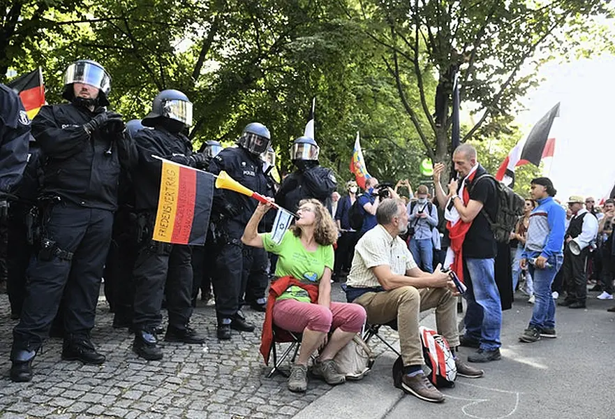 A demonstrator blows into a vuvuzela (Bernd Von Jutrczenka/AP)