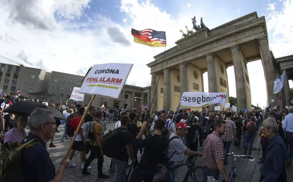 People in front of the Brandenburg Gate attend a protest rally (Michael Sohn/AP)