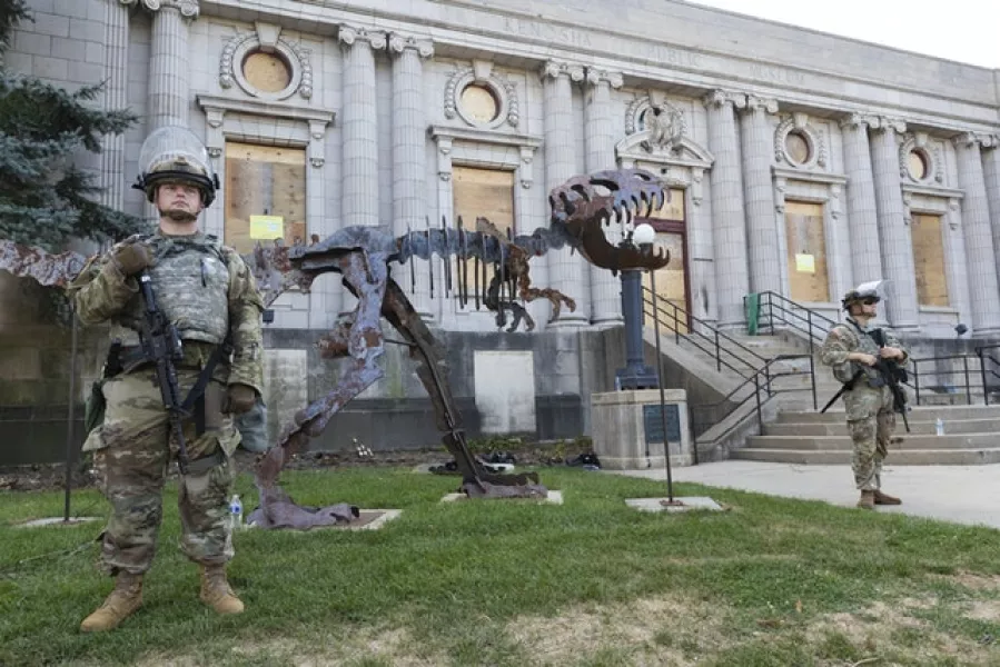 Wisconsin National Guardsmen keeps watch around the Dinosaur Discovery Museum across from a prayer gathering (Milwaukee Journal-Sentinel via AP)