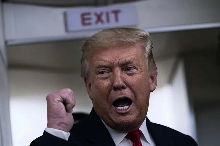 Mr Trump speaks to reporters on board Air Force One (AP)