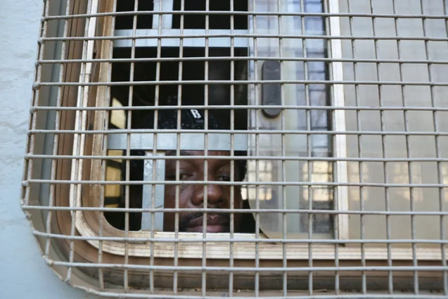 Zimbabwe Journalist Hopwell Chin’ono is seen through the window of a prison truck (AP)