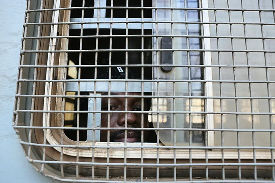 Zimbabwe Journalist Hopwell Chin’ono is seen through the window of a prison truck (AP)