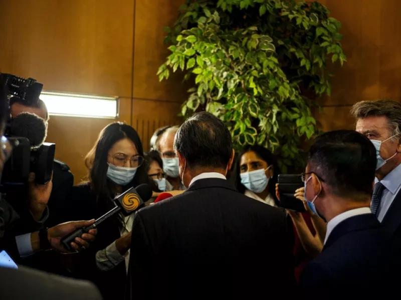 Mr Wang speaks with journalists after the press conference (Kamil Zihnioglu/AP)