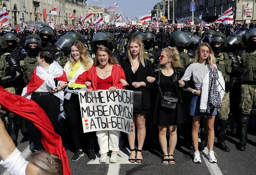 Women stand in front of riot police during the rally in Minsk (AP)