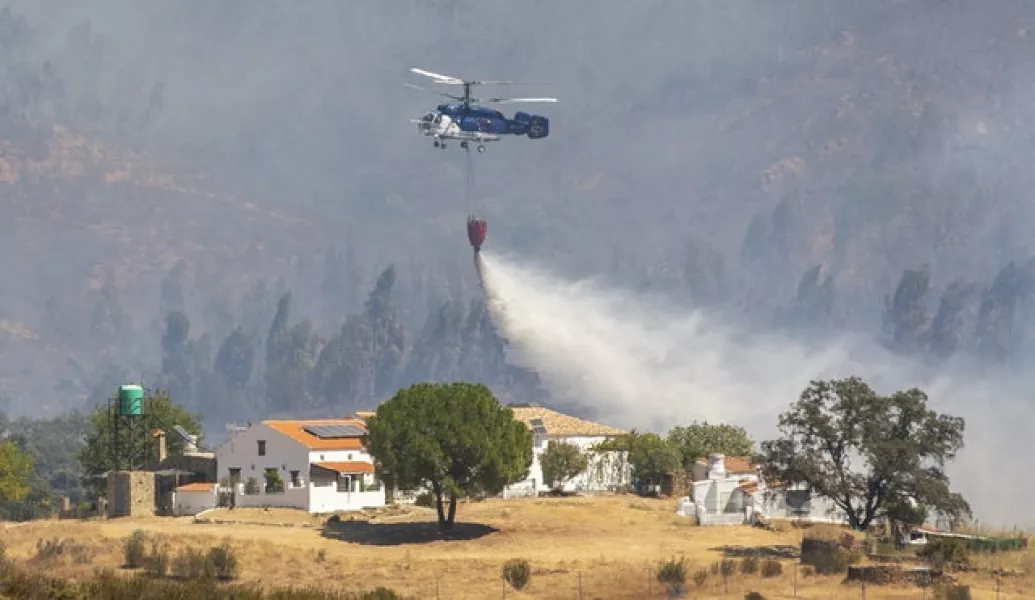 A helicopter at work trying to tackle the blaze (A Perez, Europa Press via AP)