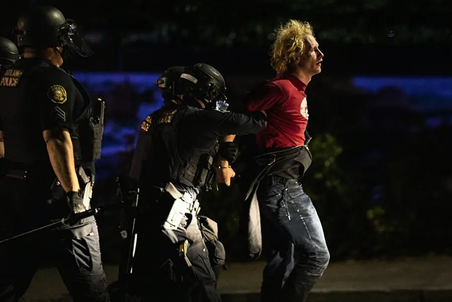 Portland police make arrests on the scene of the nightly protests in the Oregon city (AP)